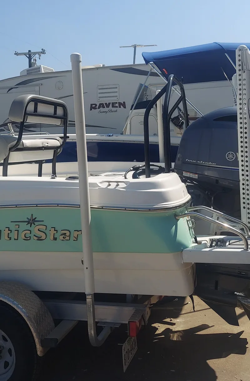 Slide: The Image of 2021 NauticStar 211 Hybrid boat on a trailer in a marina. - 15