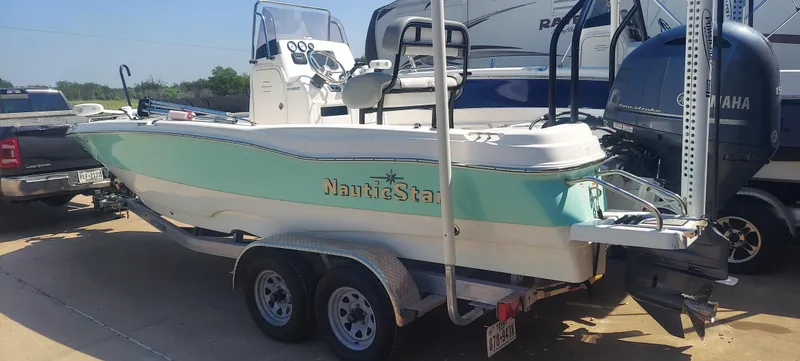 Slide: The Image of 2021 NauticStar 211 Hybrid boat on trailer, parked outdoors. - 16