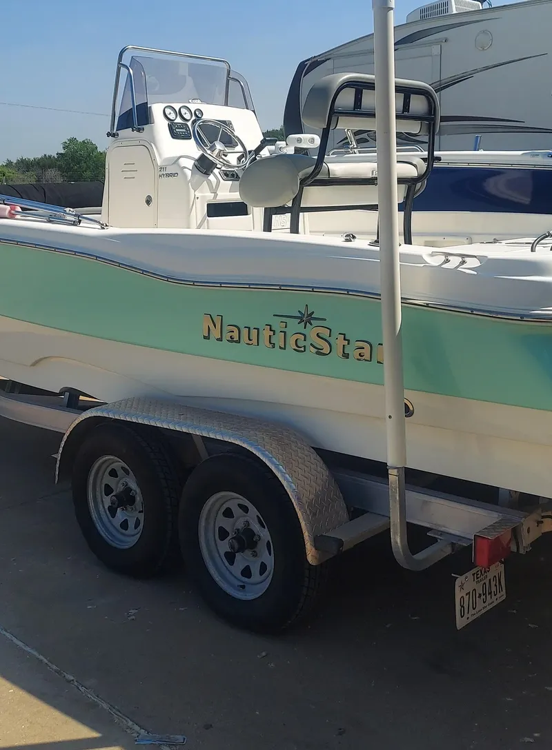 Slide: The Image of 2021 NauticStar 211 Hybrid boat on a trailer in a parking lot. - 17