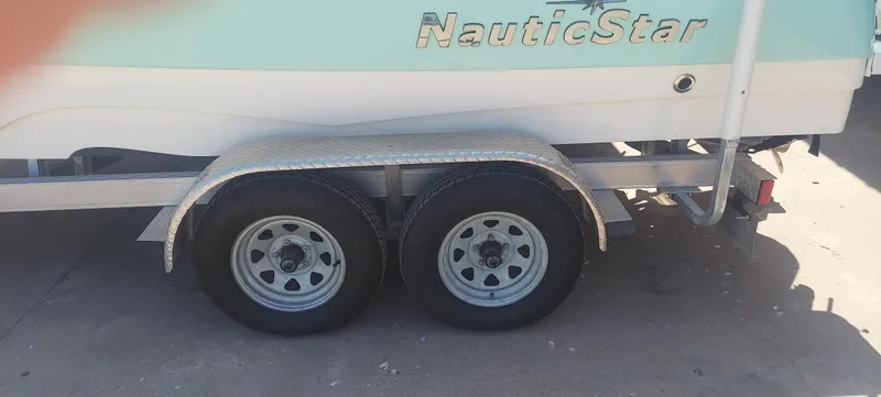 Slide: The Image of 2021 NauticStar 211 Hybrid boat on a dual-axle trailer. - 18
