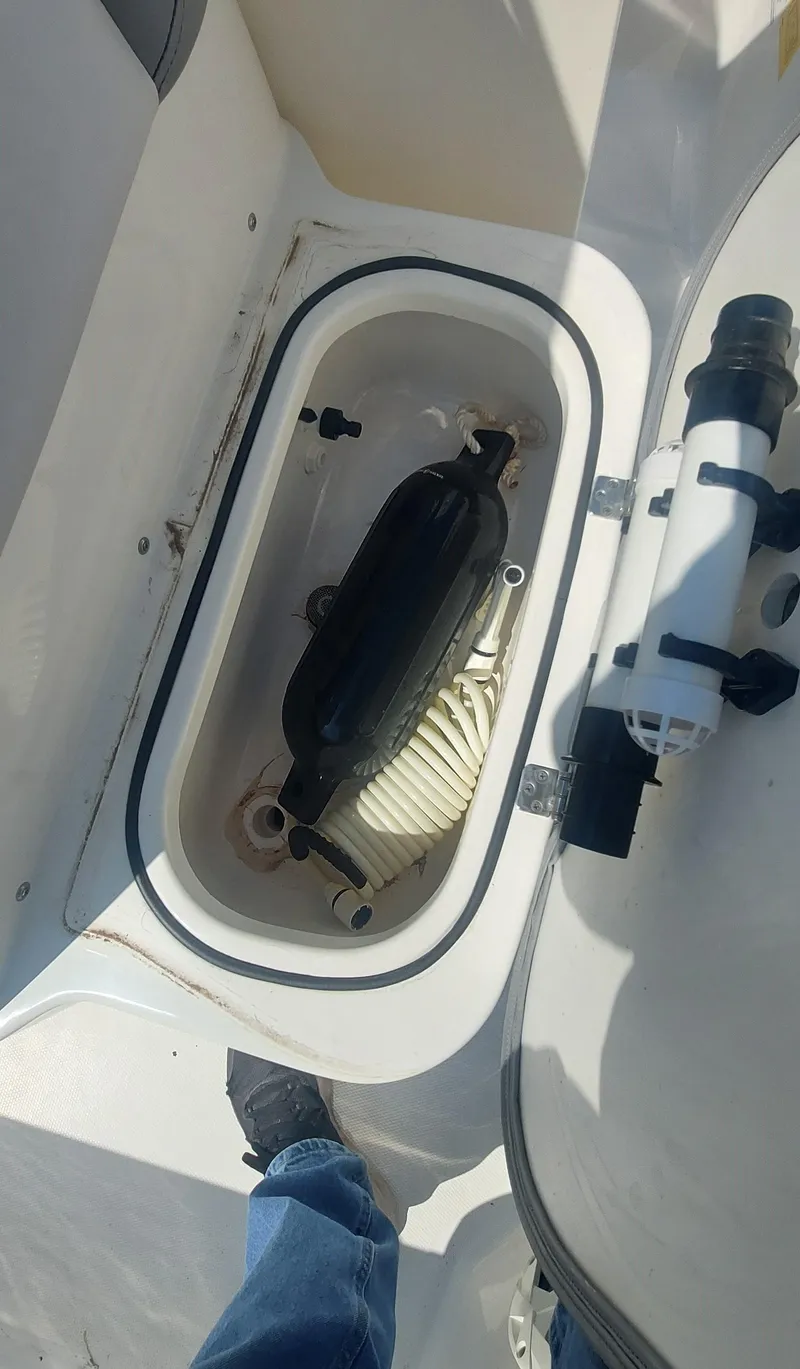 Slide: The Image of 2021 NauticStar 211 Hybrid boat storage compartment with equipment. - 2