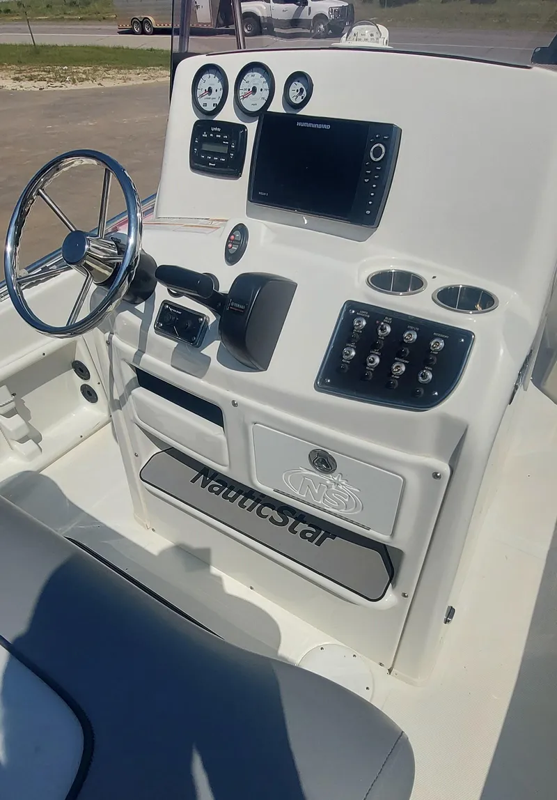 Slide: The Image of 2021 NauticStar 211 Hybrid boat console with steering wheel and navigation controls. - 9