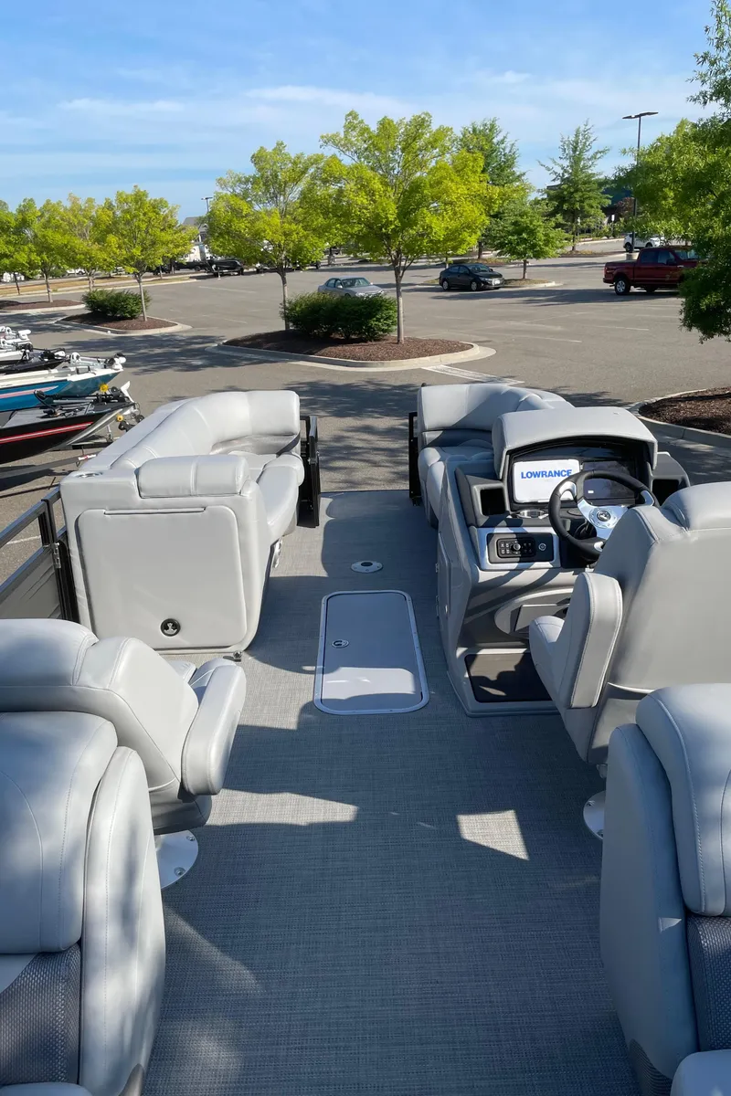 Slide: The Image of 2024 Regency 230 DL3 pontoon boat interior with plush seating and modern dashboard. - 3