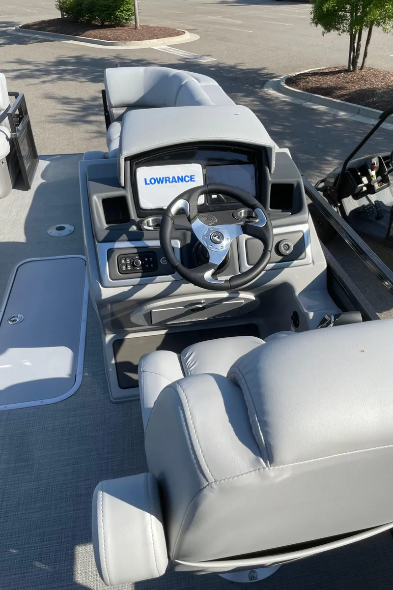 Slide: The Image of 2024 Regency 230 DL3 boat cockpit with steering wheel and Lowrance display. - 4