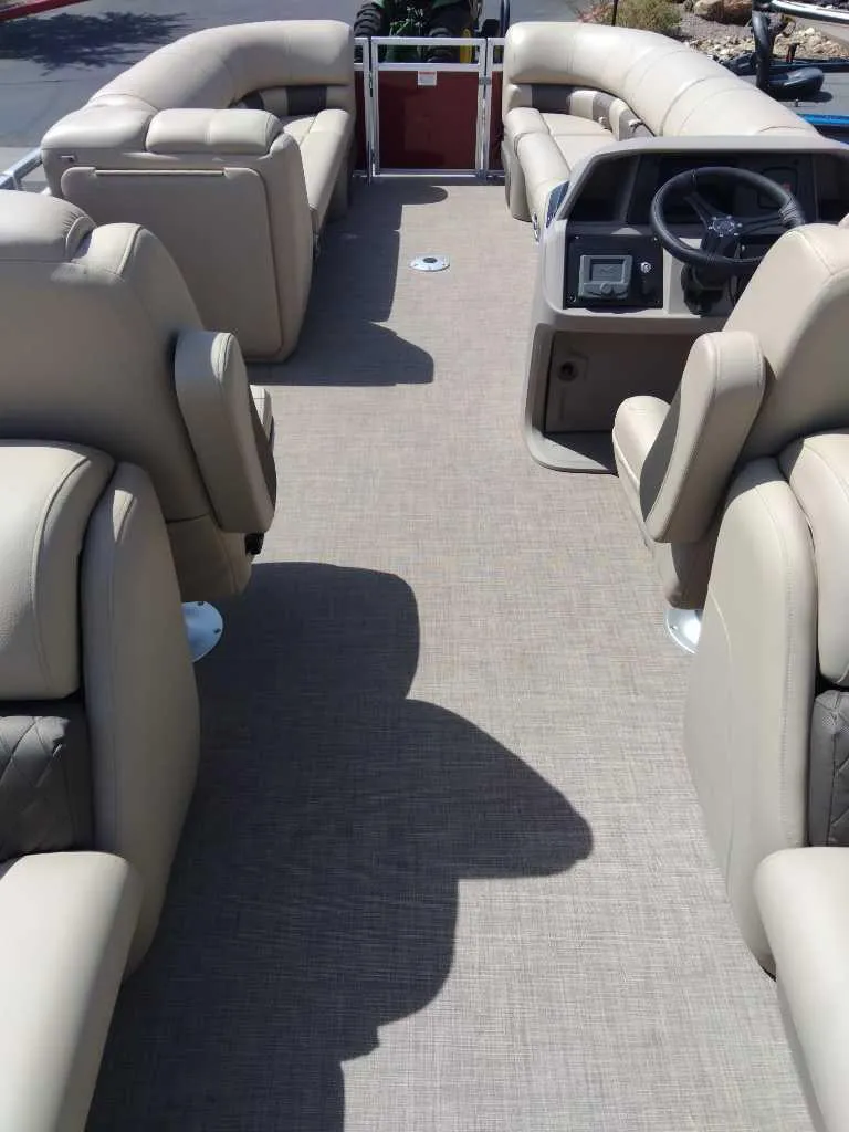 Slide: The Image of 2024 Sun Tracker Party Barge 24 DLX interior with beige seating and spacious layout. - 2