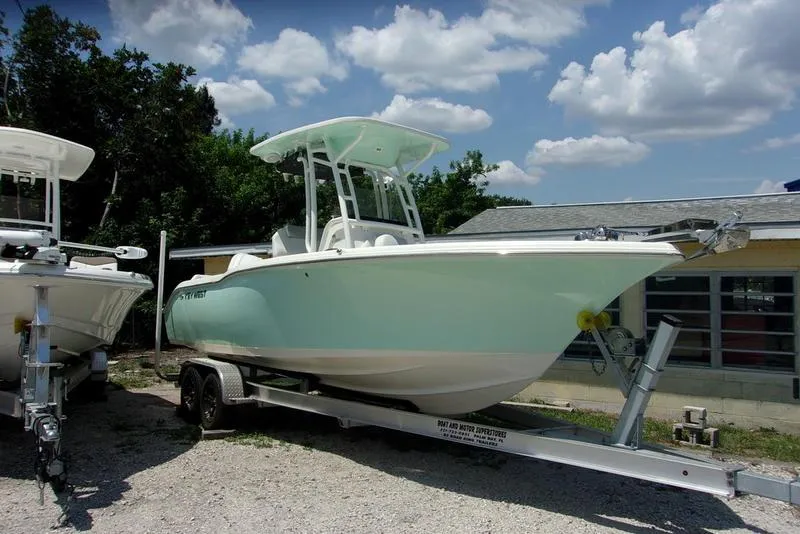 Slide: The Image of 2022 Key West 239FS boat on a trailer under a sunny sky. - 1