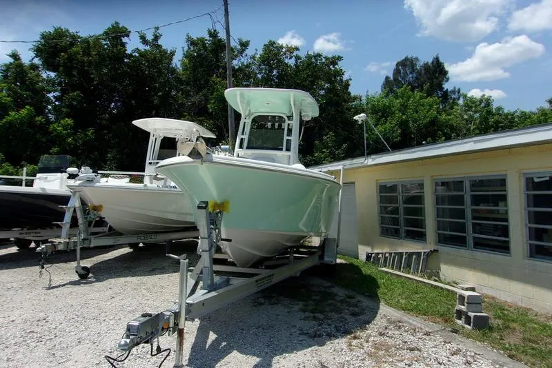 Slide: The Image of 2022 Key West 239FS boat on a trailer in a yard. - 2
