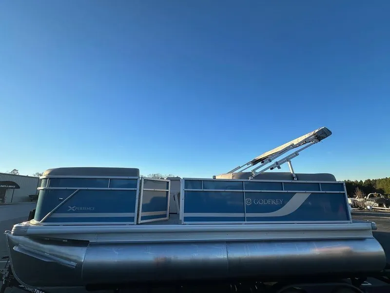 Slide: The Image of 2024 Godfrey Xperience 1886 CX pontoon boat under clear blue sky. - 4