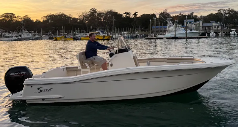 The Image of 2021 Scout 215 XSF boat on water at sunset, with marina in background. - 0