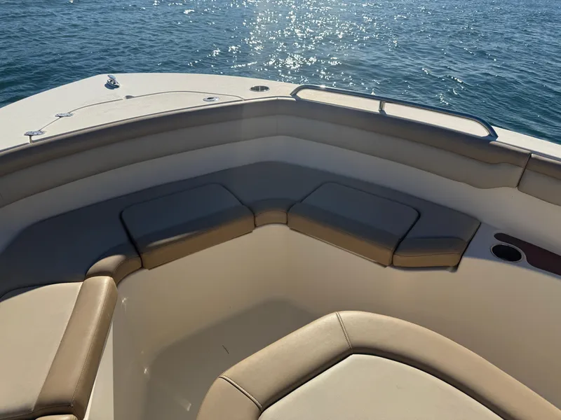 Slide: The Image of 2021 Scout 215 XSF boat interior with cushioned seating, on calm water. - 10