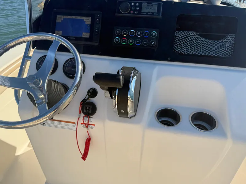 Slide: The Image of 2021 Scout 215 XSF boat dashboard with steering wheel and controls. - 12
