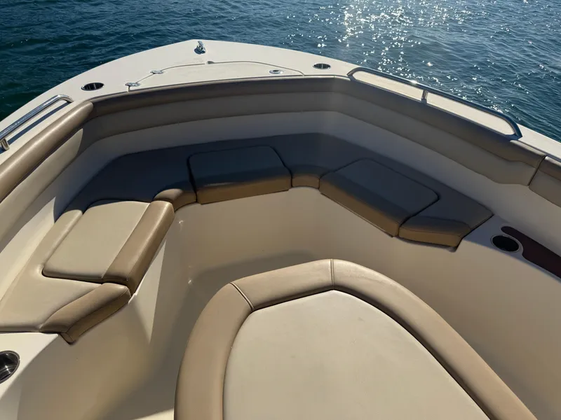 Slide: The Image of 2021 Scout 215 XSF boat interior with cushioned seating, on calm water. - 15
