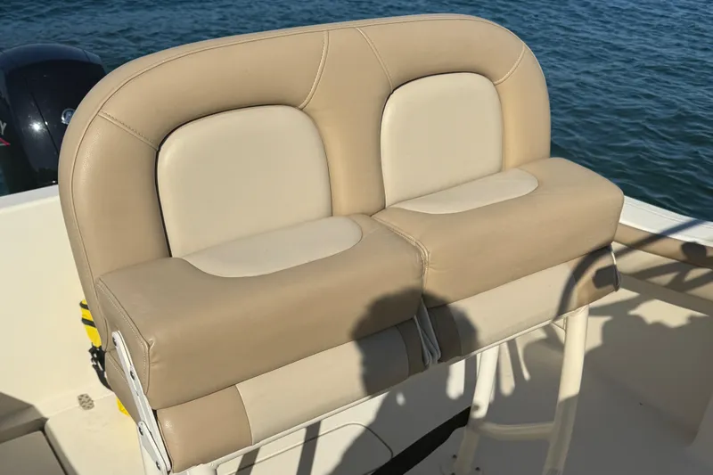Slide: The Image of 2021 Scout 215 XSF boat with beige cushioned seating, on calm water. - 17
