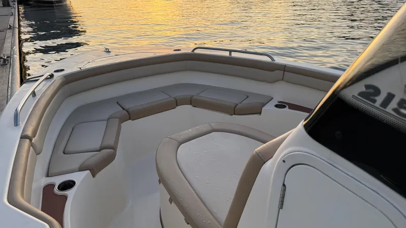 Slide: The Image of 2021 Scout 215 XSF boat interior with cushioned seating at sunset. - 22