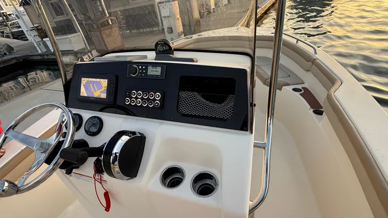 Slide: The Image of 2021 Scout 215 XSF boat dashboard with navigation controls at sunset. - 26