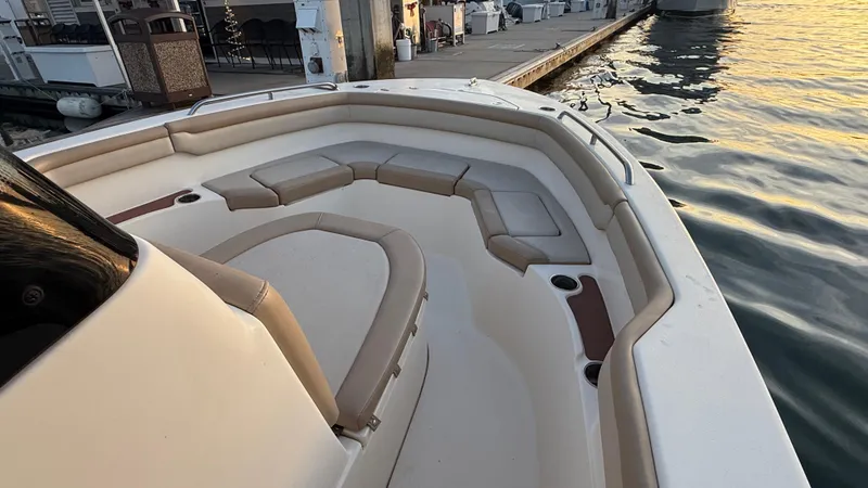 Slide: The Image of 2021 Scout 215 XSF boat with spacious seating at dockside during sunset. - 29