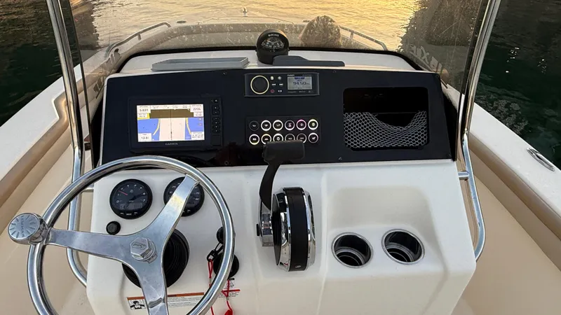 Slide: The Image of 2021 Scout 215 XSF boat dashboard with steering wheel and navigation controls. - 37