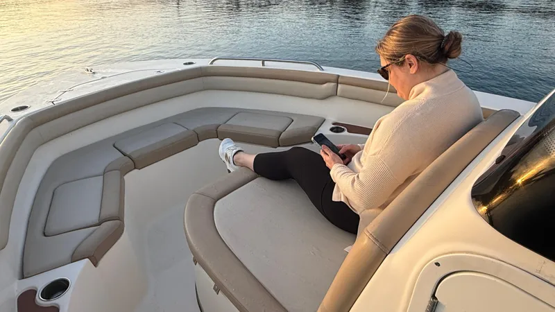 Slide: The Image of Woman relaxing on a 2021 Scout 215 XSF boat, using a smartphone. - 41