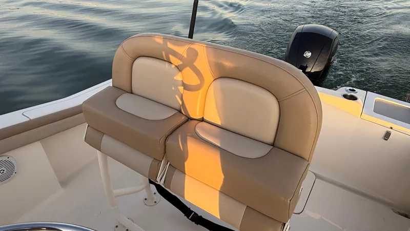 Slide: The Image of 2021 Scout 215 XSF boat seating with tan cushions on calm water. - 48