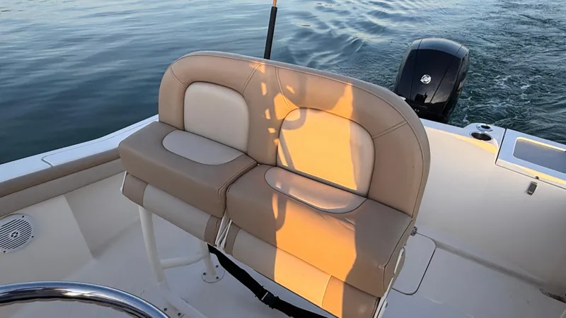 Slide: The Image of 2021 Scout 215 XSF boat interior with beige seating and outboard motor. - 49