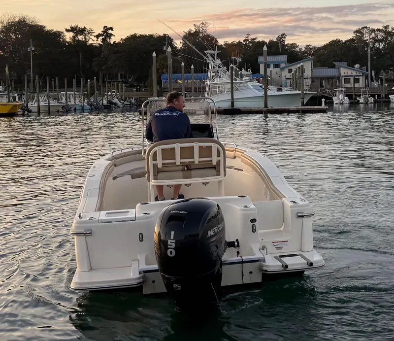 Slide: The Image of 2021 Scout 215 XSF boat with Mercury engine on calm water at sunset. - 9