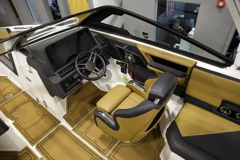 Slide: The Image of 2024 Cobalt R4 Surf boat interior with modern dashboard and tan seating. - 11