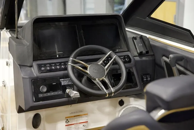 Slide: The Image of 2024 Cobalt R4 Surf boat dashboard with steering wheel and control panel. - 12