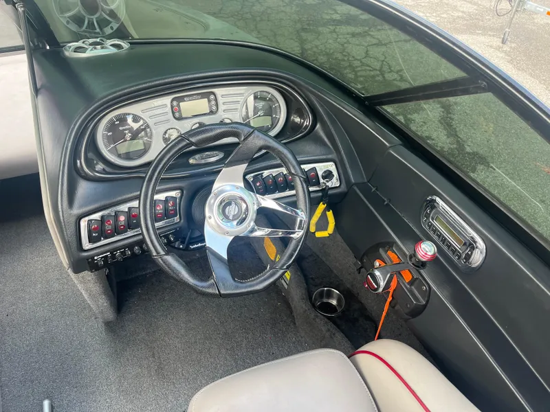 Slide: The Image of 2008 Malibu 21 vRide boat dashboard with steering wheel and control panel. - 10