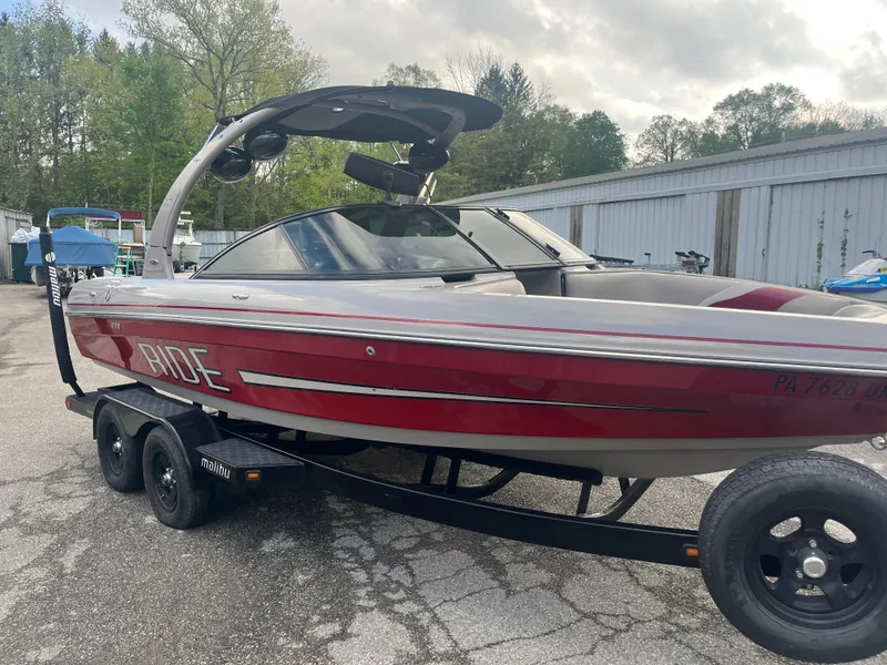 Slide: The Image of 2008 Malibu 21 vRide boat on trailer, red and white, parked outdoors. - 5