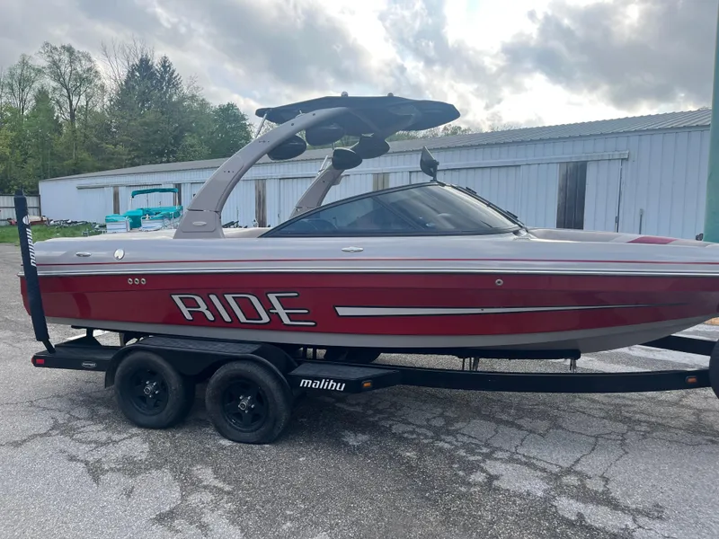 Slide: The Image of 2008 Malibu 21 vRide boat on trailer, red and gray, parked outdoors. - 6