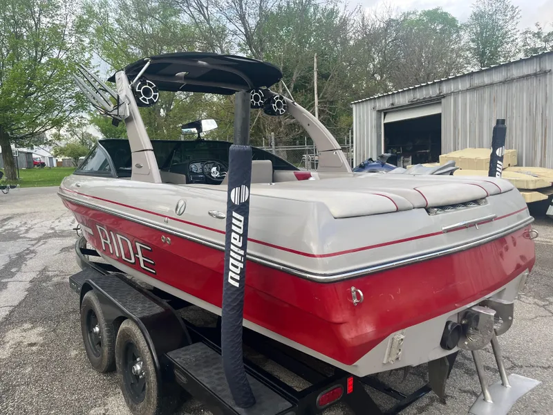 Slide: The Image of 2008 Malibu 21 vRide boat on trailer, red and white, parked outdoors. - 8