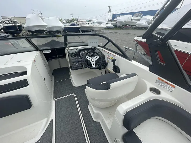 Slide: The Image of 2021 Bayliner VR6 OB boat interior with steering wheel and seating. - 7