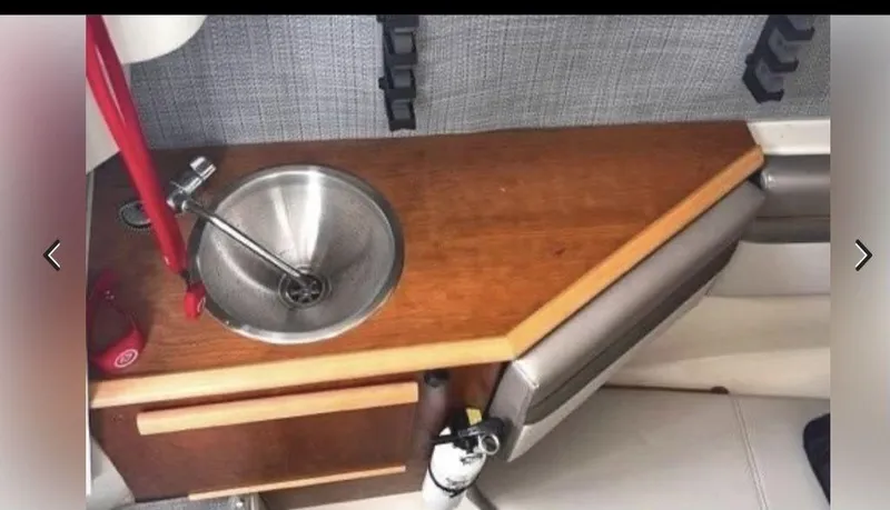 Slide: The Image of 2021 Cutwater C-24W boat interior with wooden countertop and stainless steel sink. - 11