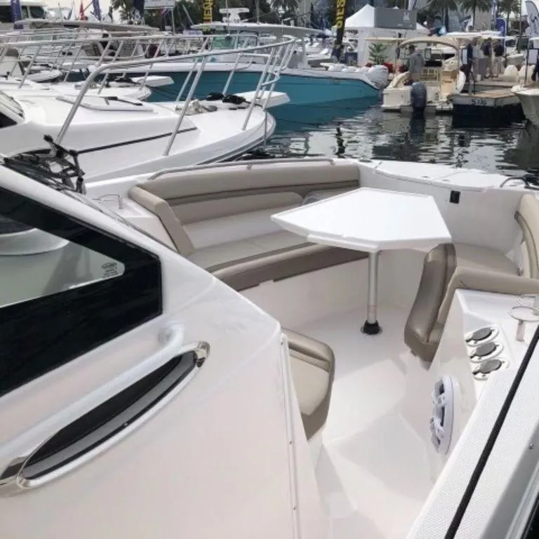 Slide: The Image of 2021 Cutwater C-24W boat interior with seating and table at a marina. - 14