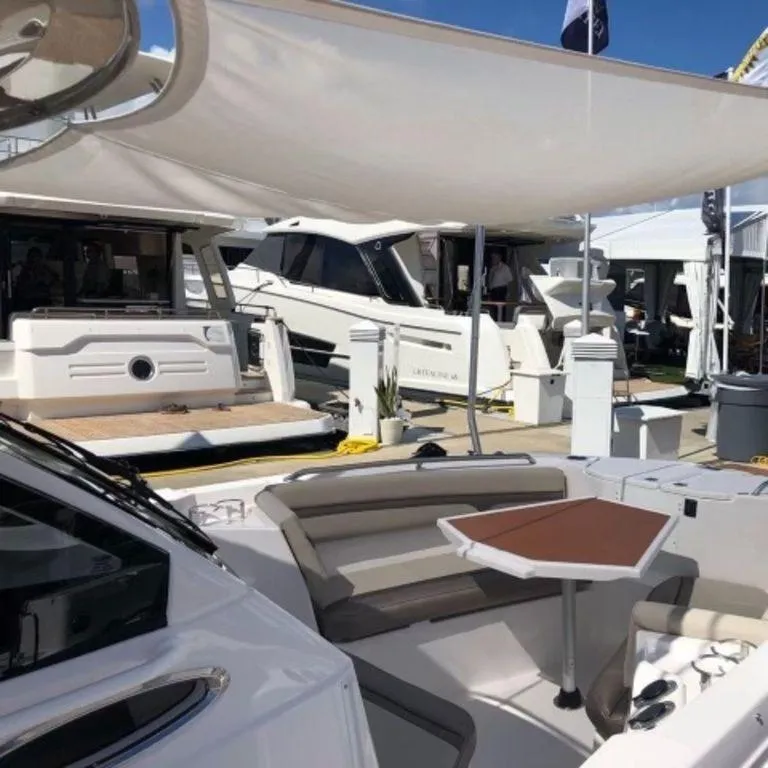 Slide: The Image of 2021 Cutwater C-24W boat interior with seating and table at a marina. - 15