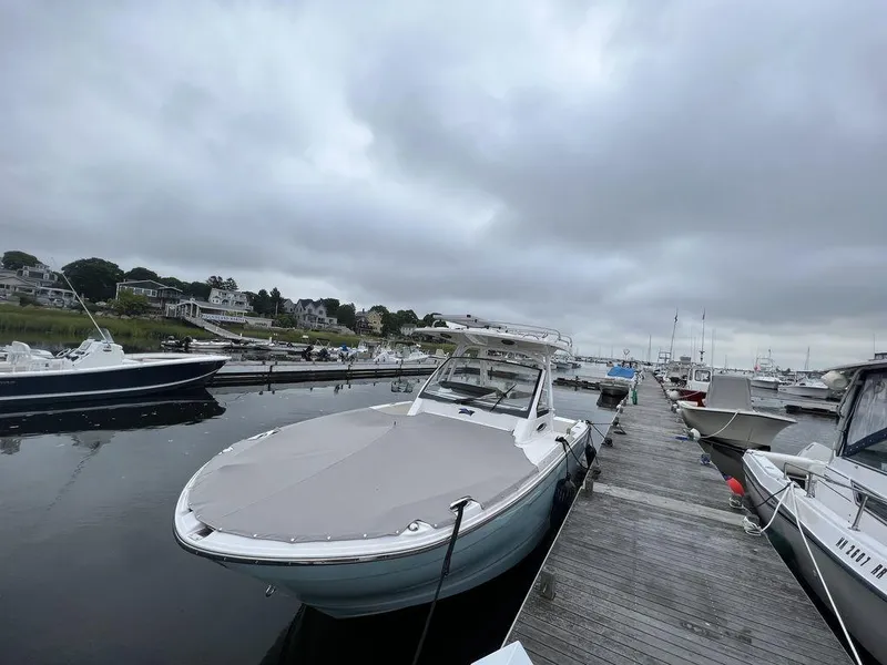 Slide: The Image of 2021 Cutwater C-24W boat docked at a marina under cloudy skies. - 4