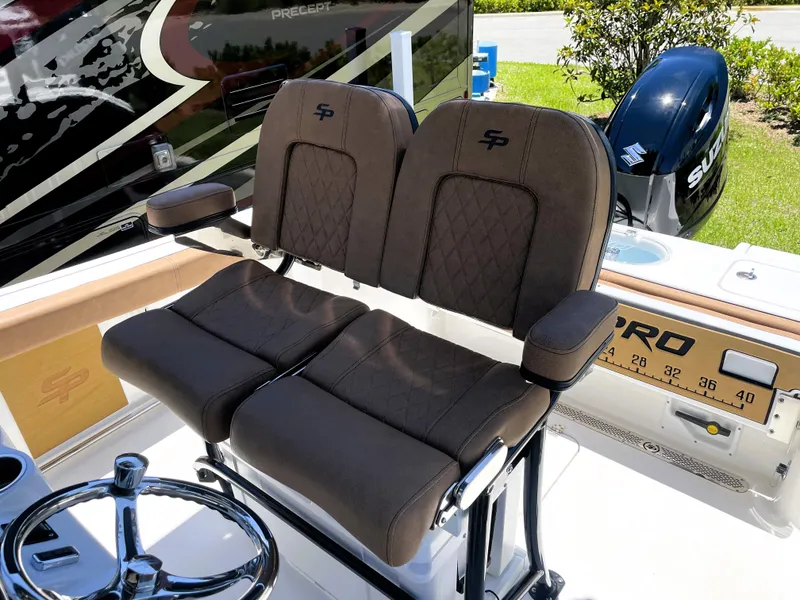 Slide: The Image of 2022 Sea Pro 219 Center Console boat with dual brown captain's chairs and Suzuki outboard motor. - 35