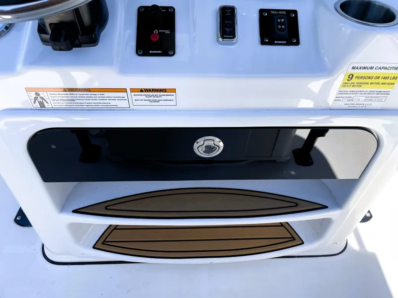 Slide: The Image of 2022 Sea Pro 219 Center Console boat dashboard with storage compartments and control switches. - 46