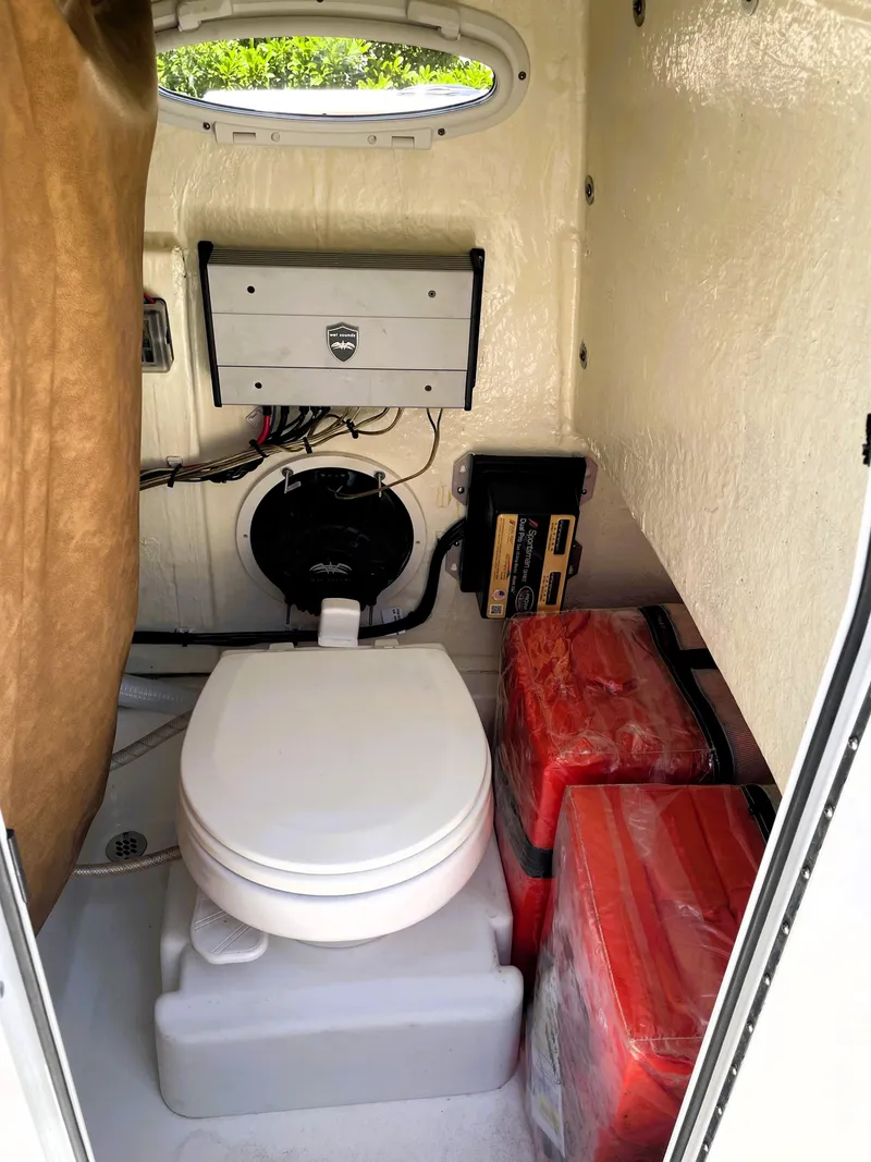 Slide: The Image of 2022 Sea Pro 219 Center Console boat interior with marine toilet and storage. - 48