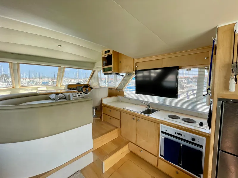Slide: The Image of 1999 Californian 39 yacht interior with kitchen, TV, and helm station. - 11