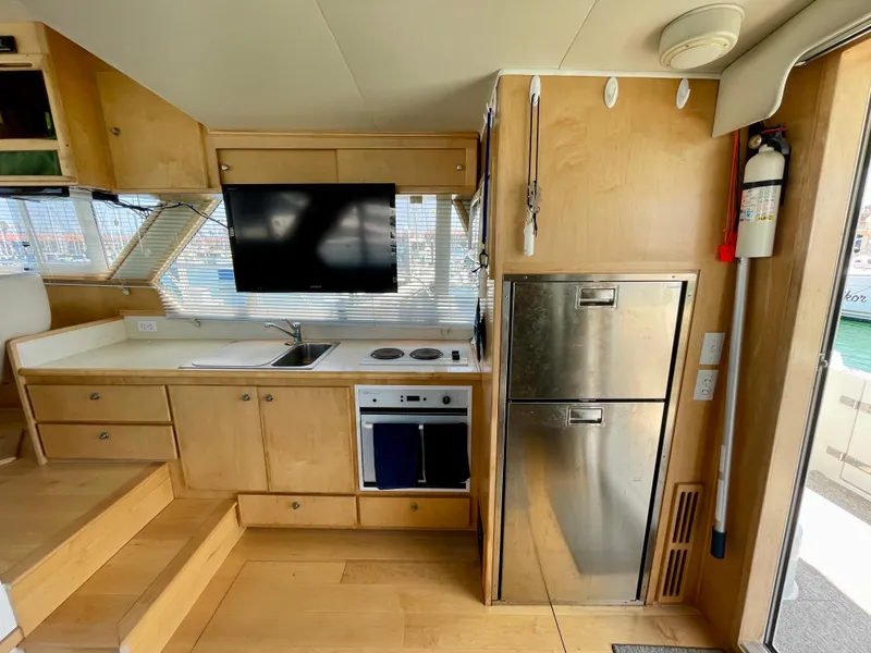 Slide: The Image of 1999 Californian 39 yacht kitchen with stainless steel appliances and wooden cabinetry. - 12