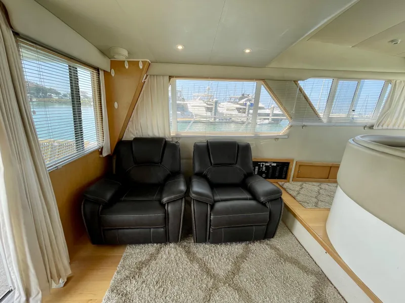 Slide: The Image of Interior of a 1999 Californian 39 yacht with black leather recliners and large windows. - 14