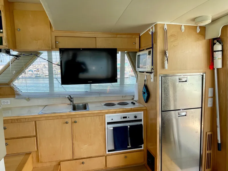 Slide: The Image of Compact kitchen area in a 1999 Californian 39 boat with modern appliances. - 19