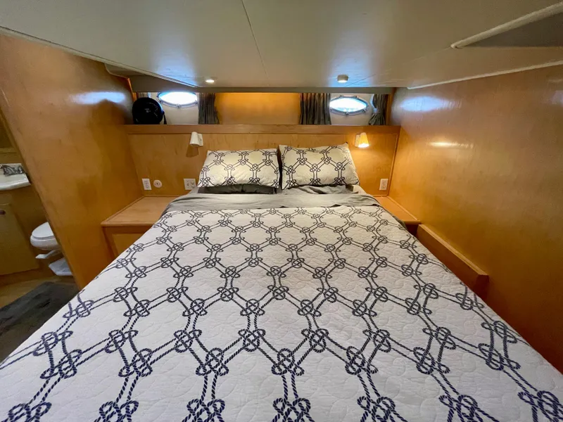 Slide: The Image of Cozy bedroom in a 1999 Californian 39 yacht with nautical-themed bedding. - 25