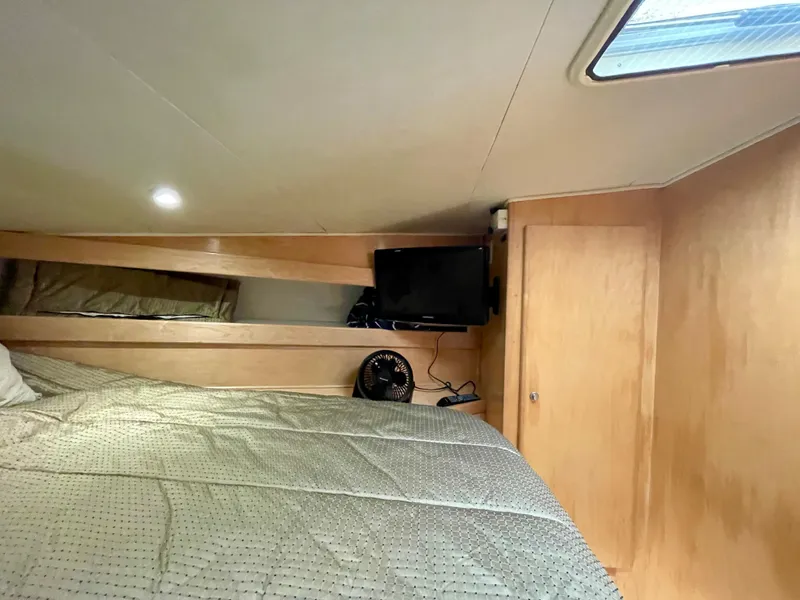 Slide: The Image of Cozy cabin interior of a 1999 Californian 39 yacht with bed, TV, and fan. - 34