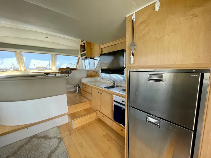 Slide: The Image of Interior of 1999 Californian 39 yacht with modern kitchen and seating area. - 38