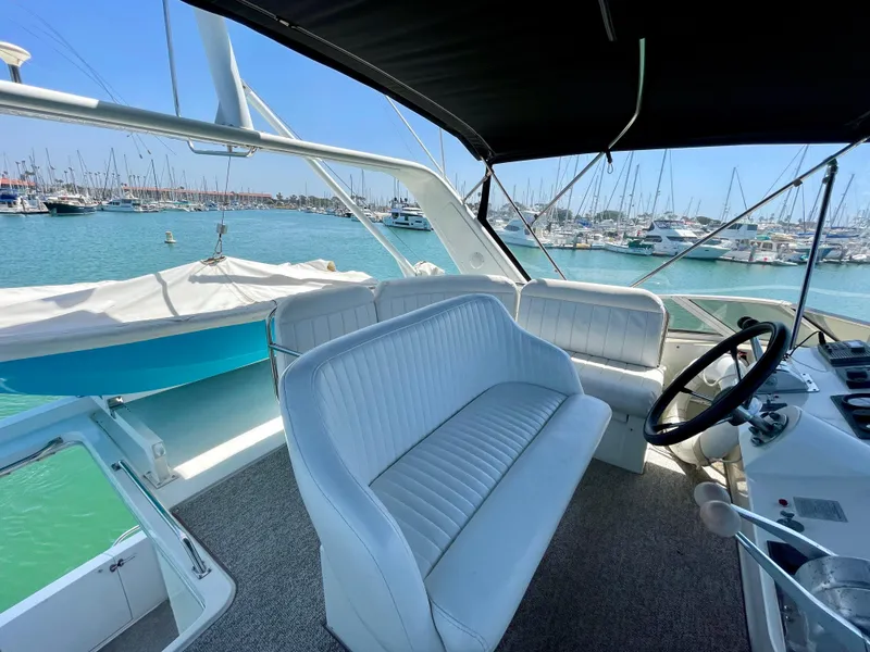 Slide: The Image of 1999 Californian 39 yacht interior with white seating and marina view. - 47