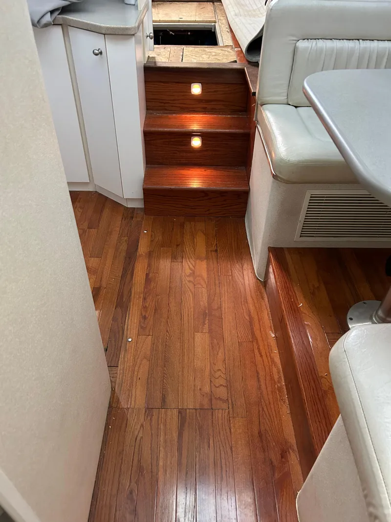 Slide: The Image of Interior of a 1995 Silverton AFT CABIN yacht with wooden flooring and cushioned seating. - 15