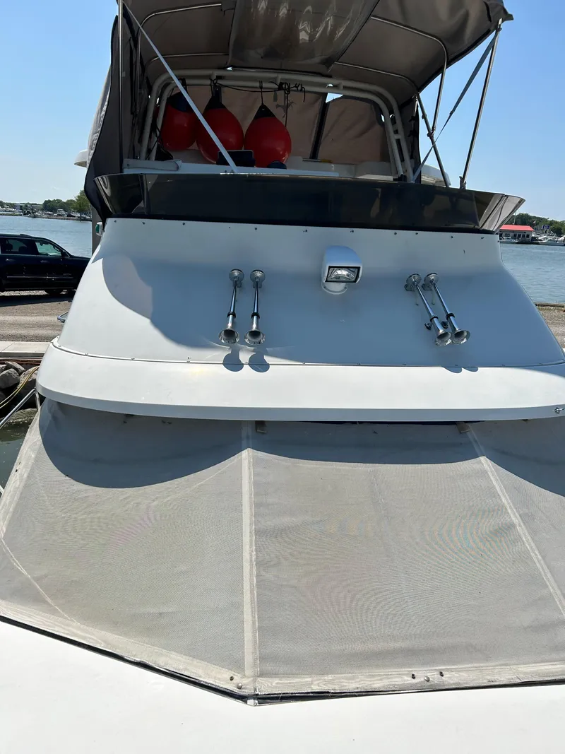 Slide: The Image of 1995 Silverton AFT CABIN boat docked, featuring a shaded upper deck and sleek design. - 17