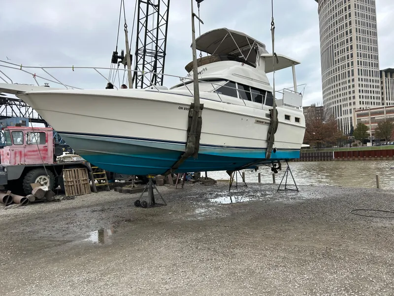 Slide: The Image of 1995 Silverton AFT CABIN boat lifted on dockside crane for maintenance. - 2